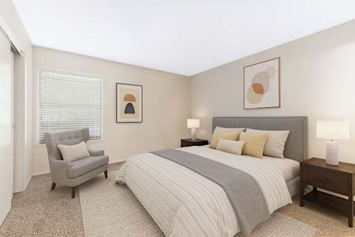A bedroom with a bed, chair, and two lamps.