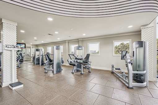 A gym with a variety of equipment including weights and machines.