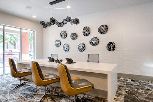A white desk with a chair in front of it and a wall with circular decorations.