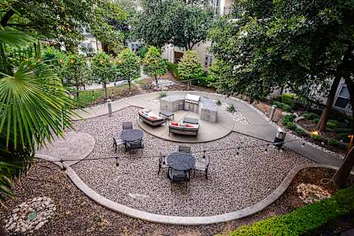 A patio with a table and chairs surrounded by trees.