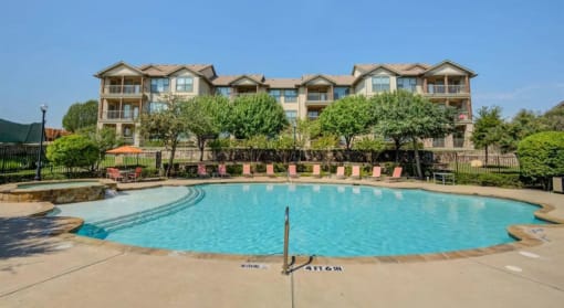 an outdoor pool with an apartment building in the background