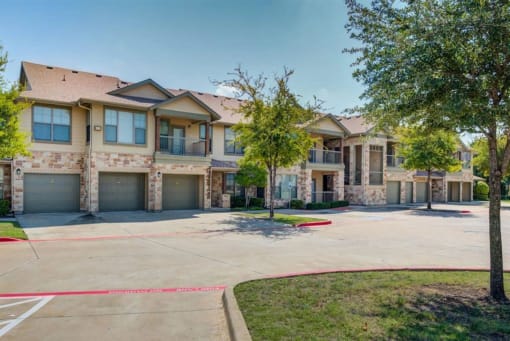 a large house with a driveway and trees in front of it