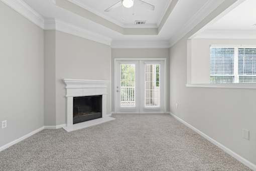A room with a fireplace and a window with blinds.