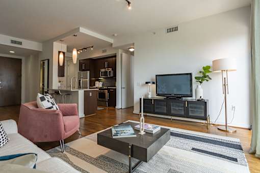 A modern living room with a pink armchair and a black coffee table.