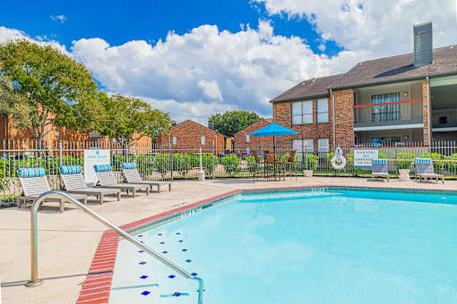 A pool with a red and blue border and a metal railing.