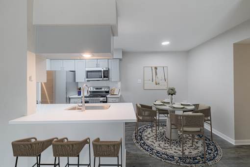 A kitchen with a dining table and chairs.