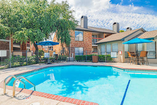 A swimming pool surrounded by a fence and trees.