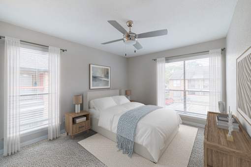 A bedroom with a bed, nightstand, and window.