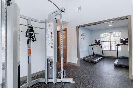 A gym with treadmills and a weight machine.