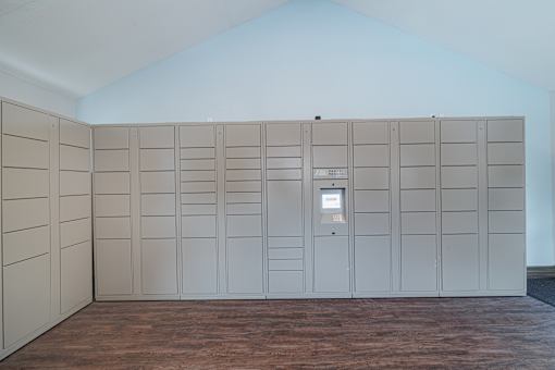 A room with a wall of lockers and a door on the right.