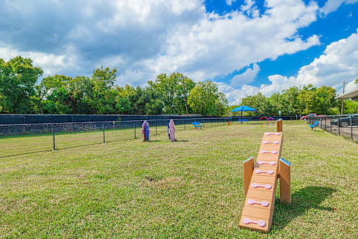 A playground with a slide and two people in the distance.