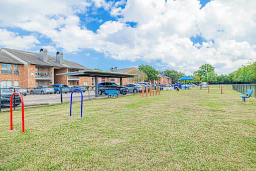A playground with a blue umbrella and a red pole.