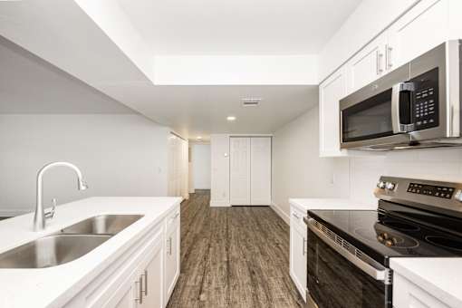 a kitchen with white cabinets and black appliances and a sink