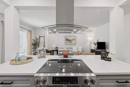 A modern kitchen with a stove top oven and a large island.