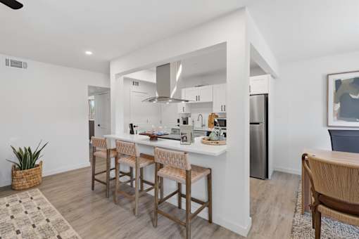 A kitchen with a bar area and a refrigerator.