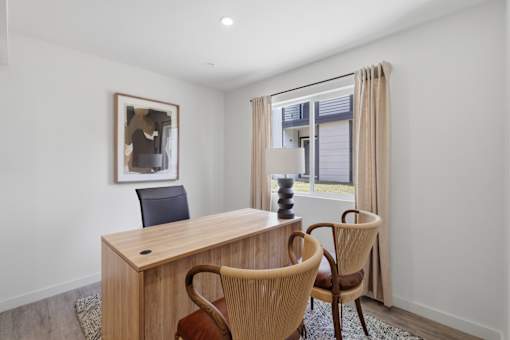 A room with a desk and two chairs.