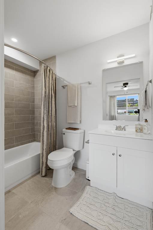A white bathroom with a toilet, sink, and bathtub.