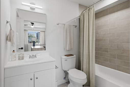 A white bathroom with a toilet, sink, and shower.