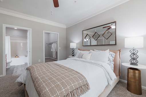 A bedroom with a large bed and a mirror on the wall.