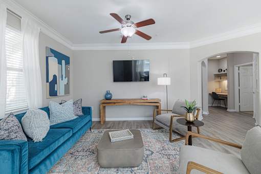 A living room with a blue couch, a television, and a rug.