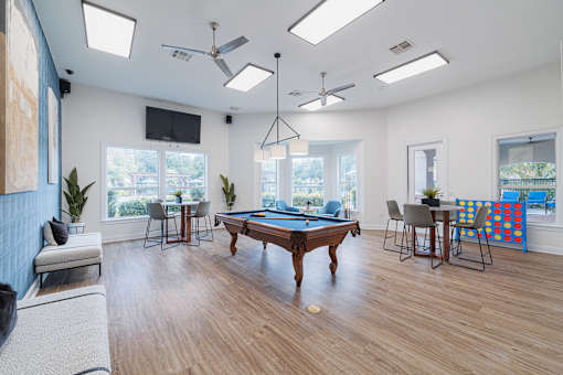 A room with a pool table and a television.