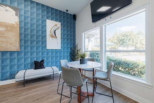A blue wall with a white bench and a painting of a bird on it.