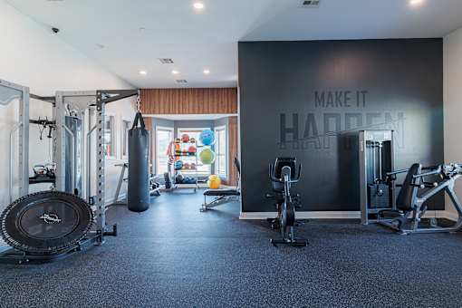 A gym with a variety of equipment including a treadmill, weights, and a punching bag.