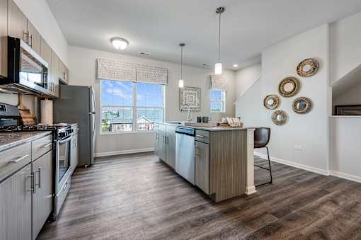A modern kitchen with a wooden floor and a large island.