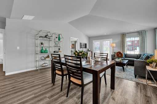 A modern dining room with a wooden table and chairs.