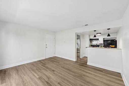 A room with a white kitchen island and wooden floors.