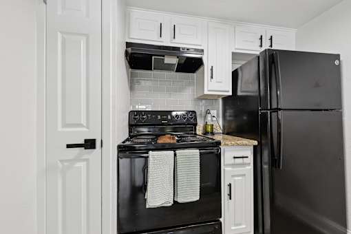 A black oven with a white towel hanging on it.