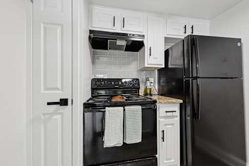 A black oven with a white towel hanging on it.
