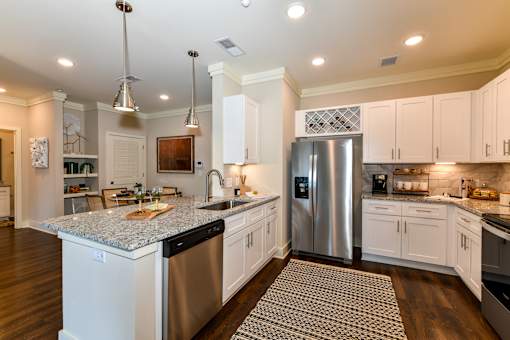 A kitchen with a granite countertop and stainless steel appliances.