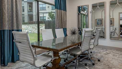 A dining room with a table and chairs.