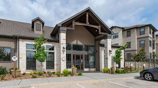A modern building with a stone facade and a large glass entrance.