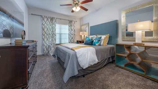A bedroom with a bed, dresser, and mirror.