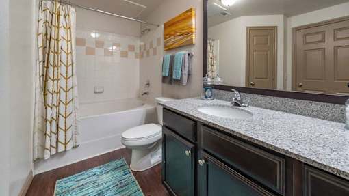 A bathroom with a toilet, sink, and shower.
