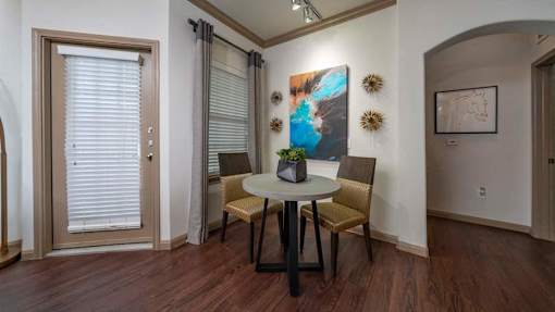 A dining room with a table and chairs.