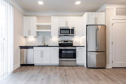 A modern kitchen with stainless steel appliances and white cabinets.