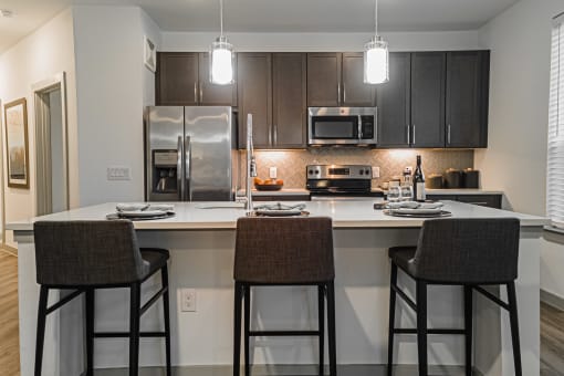a kitchen with a large island with three stools