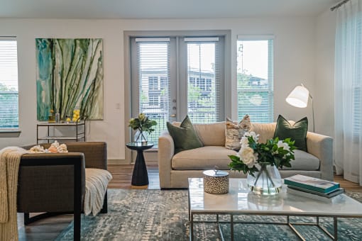 a living room with beige couches and a coffee table with a vase of flowers