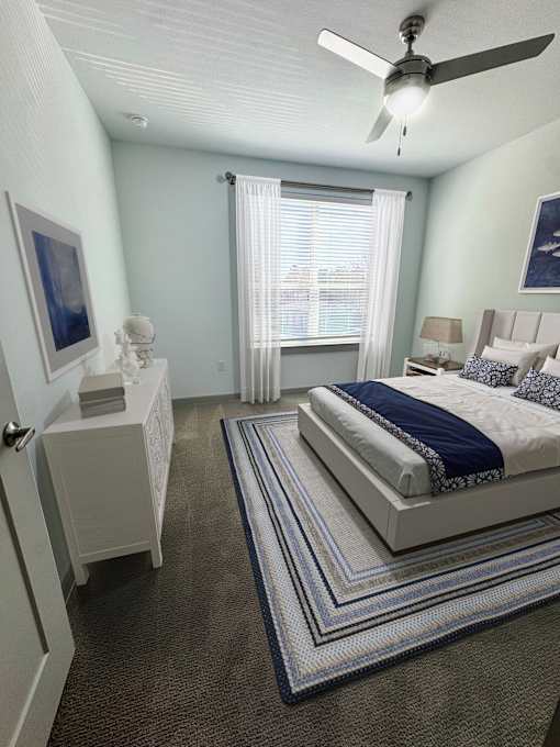 A bedroom with a bed, nightstand, and a ceiling fan.