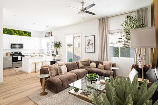 A modern living room with a brown couch and a glass coffee table.