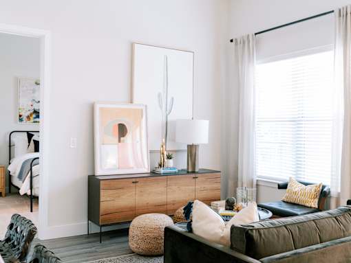 A modern living room with a green sofa and a wooden cabinet.