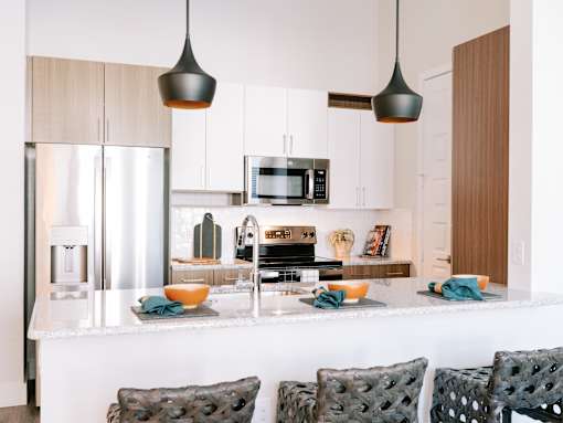 A modern kitchen with a white countertop and a refrigerator.