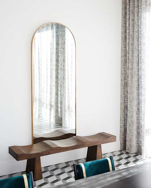 A mirror with a wooden frame is leaning against a wall.