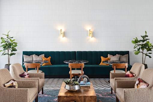 A living room with a green couch, two chairs, and a coffee table.
