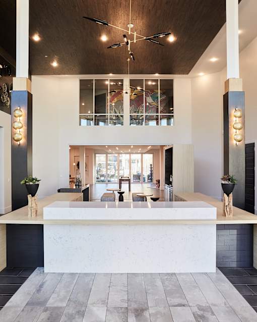 A reception area with a white counter and a ceiling fan.