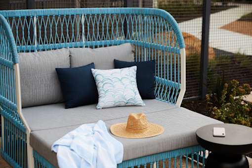 A blue chair with a hat on it.