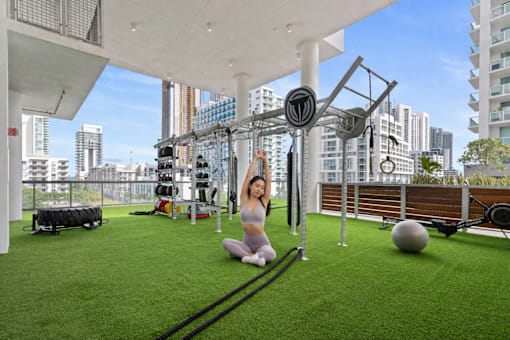 A woman exercising in a gym with a view of the city.